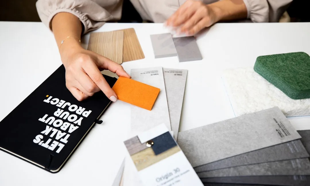 Interior designer comparing warm and cool material swatches including wood, fabric, and stone samples on a white table