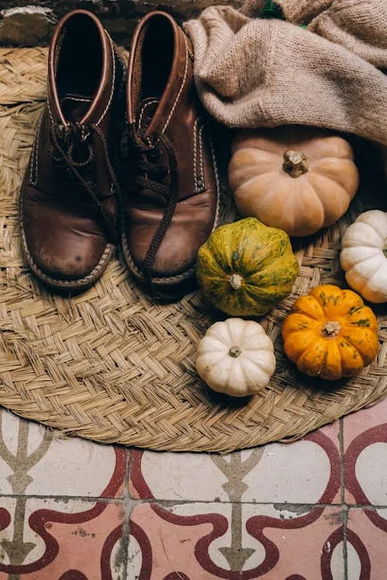 Fall entryway decor with brown leather boots, mini pumpkins, and burlap on a woven mat over patterned tile