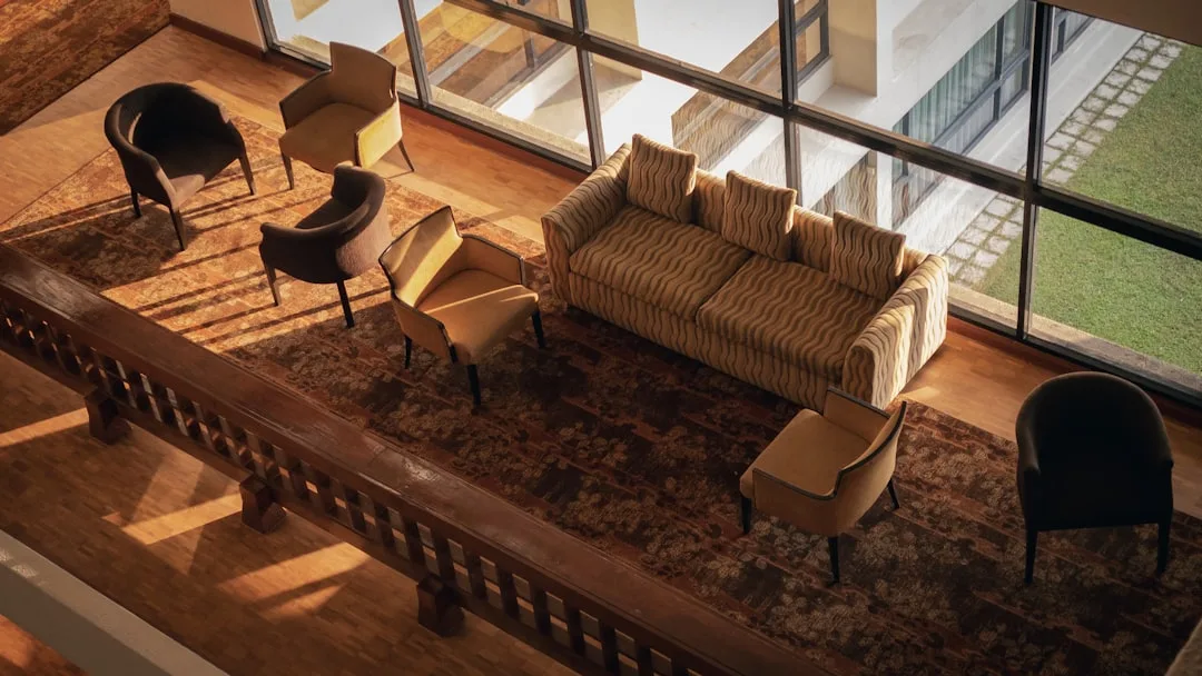 Overhead view of open floor plan seating area with striped sofa, accent chairs, patterned rug near floor-to-ceiling wind