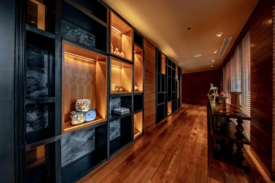 Illuminated built-in cabinet shelves with organized display items using zone method in a luxury corridor