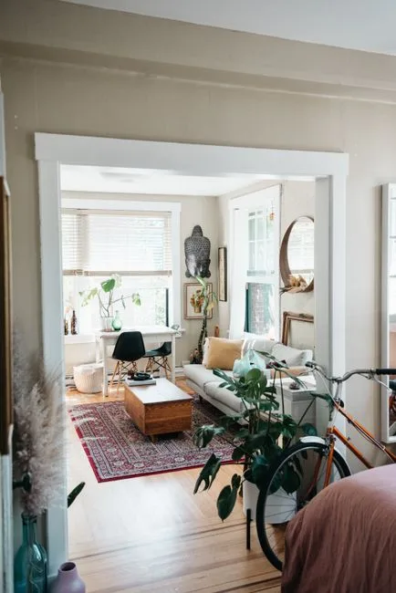 Bohemian living room with clear traffic flow path through doorway, white sofa, wood coffee table, and Persian rug