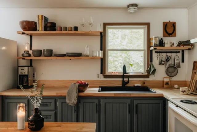 Open galley kitchen with dark gray cabinets, butch