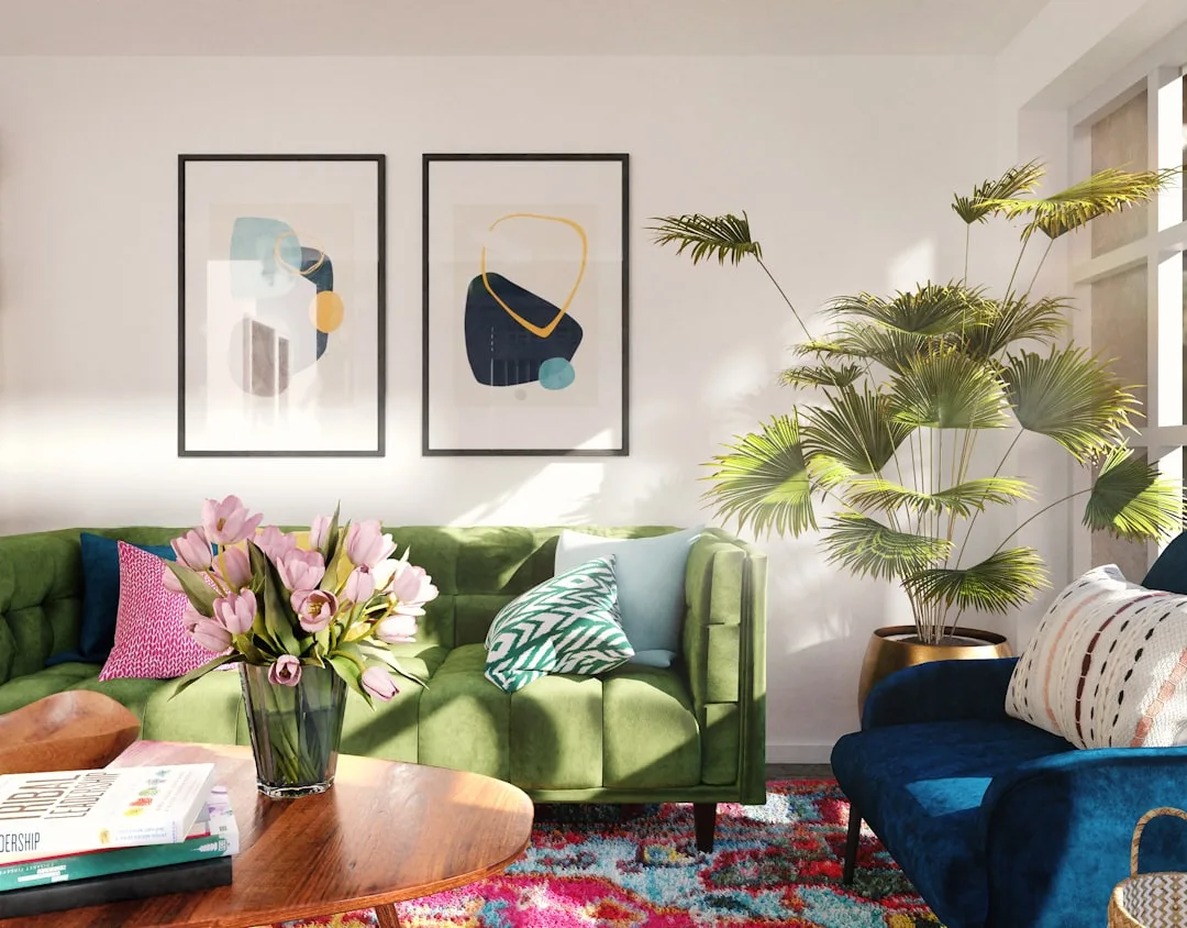 Colorful living room with green velvet sofa, blue armchair, abstract wall art, and tropical plant for color reading tips