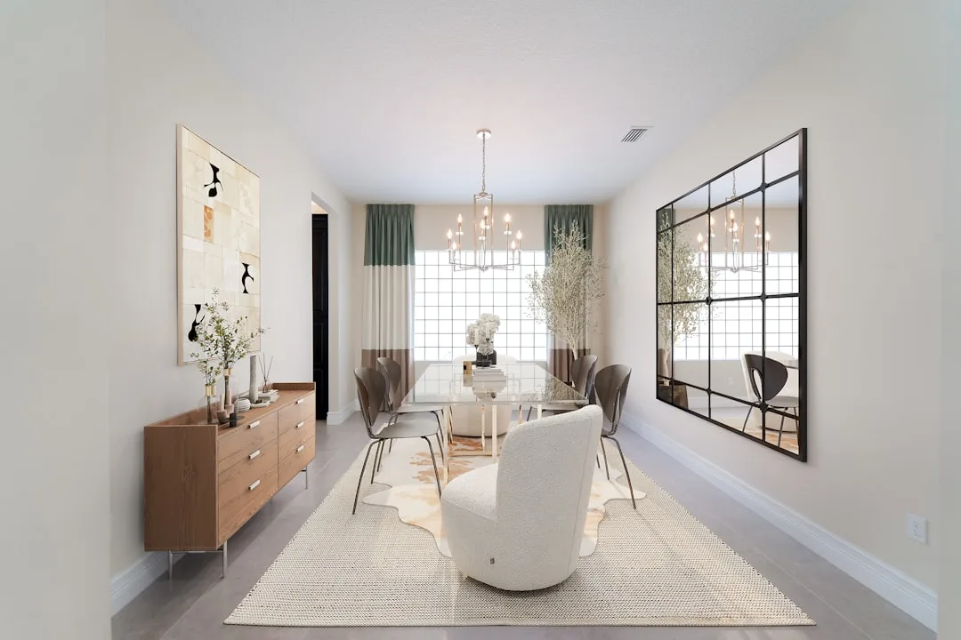 Modern dedicated dining room with glass table, boucle chair, wood sideboard, and large wall mirror in neutral tones