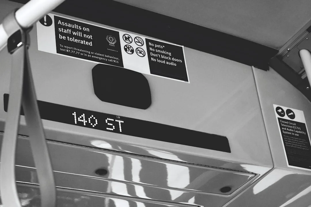 Transit vehicle LED display showing station label '140 ST' alongside instructional signs inside public transport