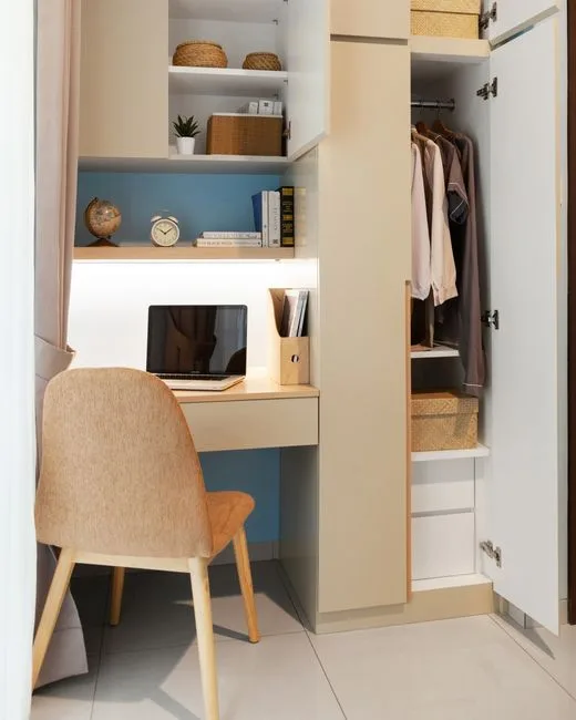 Closet workspace with built-in LED under-shelf lighting illuminating a compact desk setup with laptop and shelving
