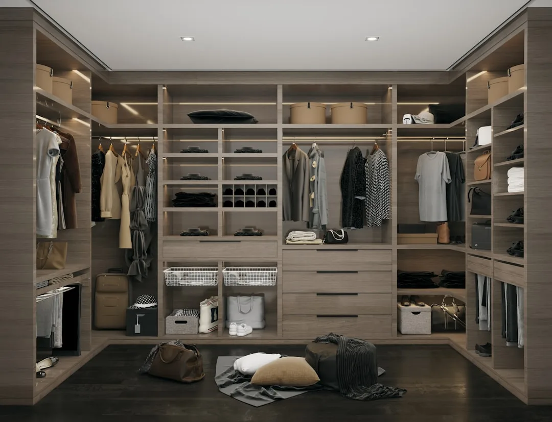 Luxury walk-in closet with hanging rails, folded clothes, drawers, and categorized storage zones in warm wood finish