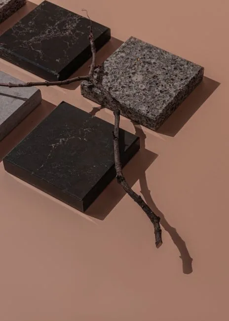 Black marble, granite, and stone material samples on terracotta surface showing different finishes and textures