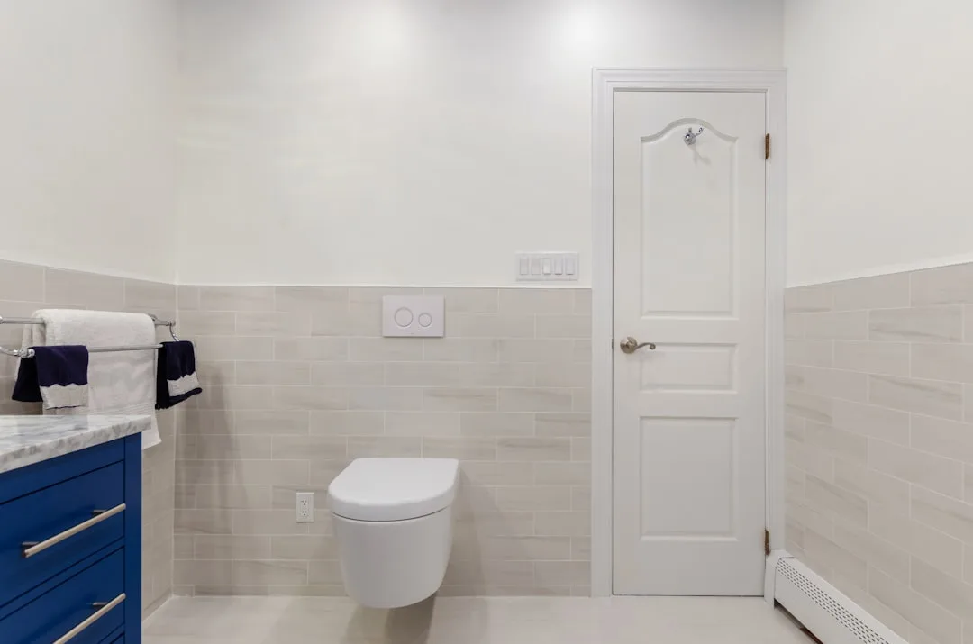 Wall-mounted toilet in modern bathroom with blue v