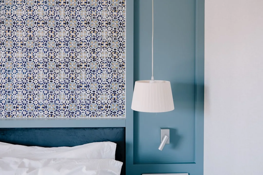 Blue bedroom headboard wall with decorative Portuguese azulejo tile panel and white pendant lamp