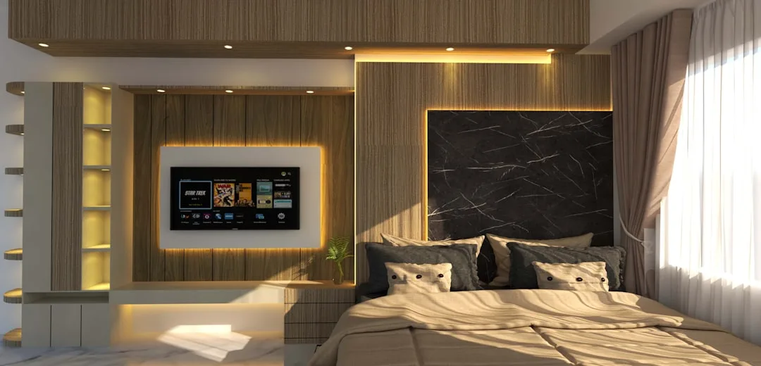 Modern bedroom with warm wood panel walls, black marble headboard, ambient LED lighting, and wall-mounted TV unit