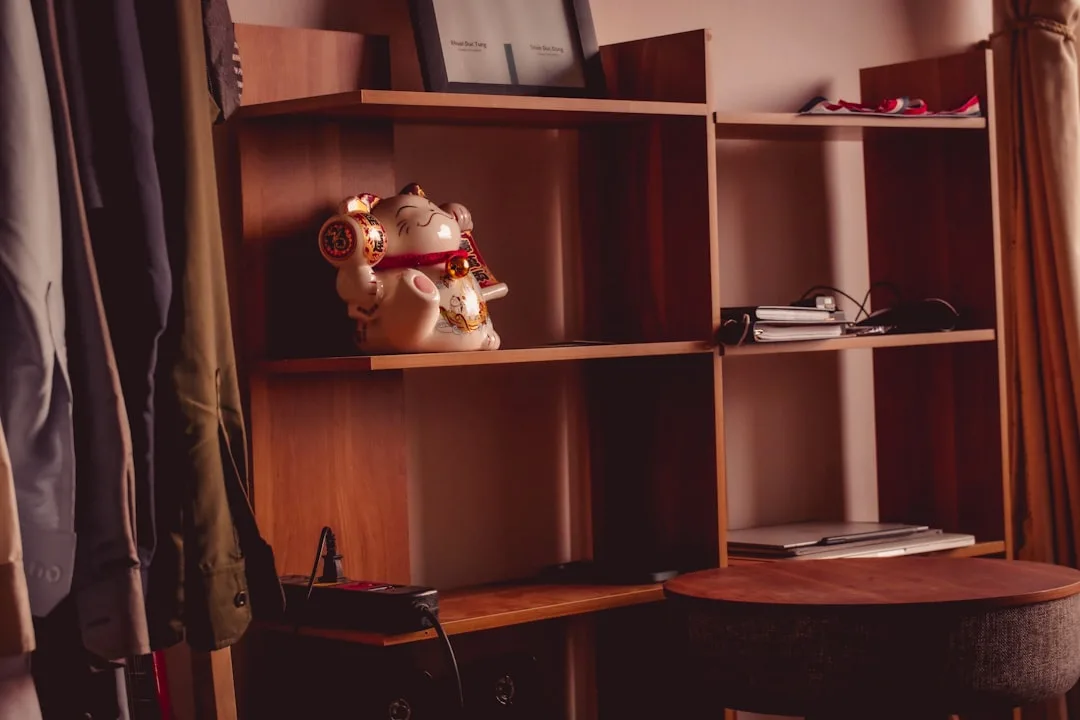 Wooden open shelving unit with lucky cat figurine demonstrating shelf placement and ergonomic storage organization
