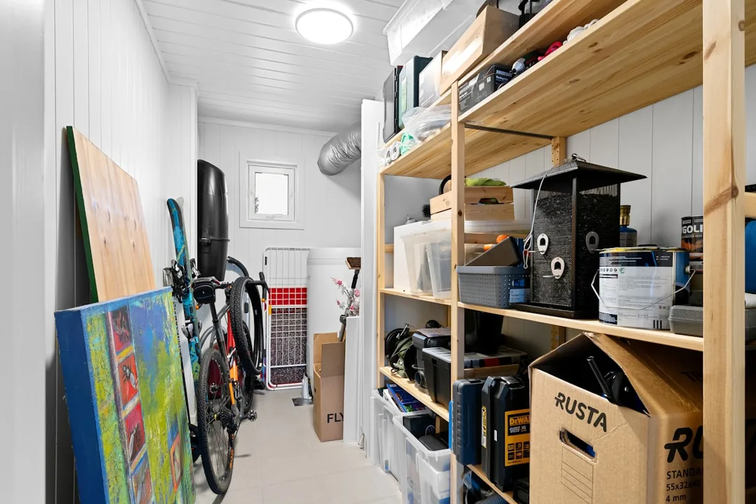 Organized storage room with wooden shelving, tools, boxes, and bicycle showing structured storage architecture