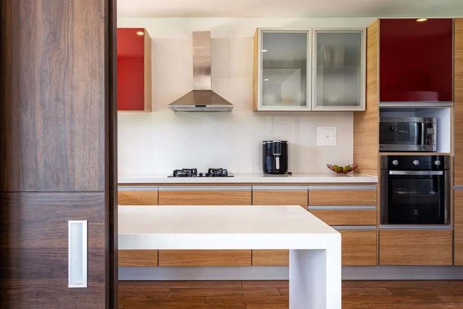 Modern kitchen with open and closed cabinets featuring wood veneer, red gloss doors, frosted glass panels and white coun
