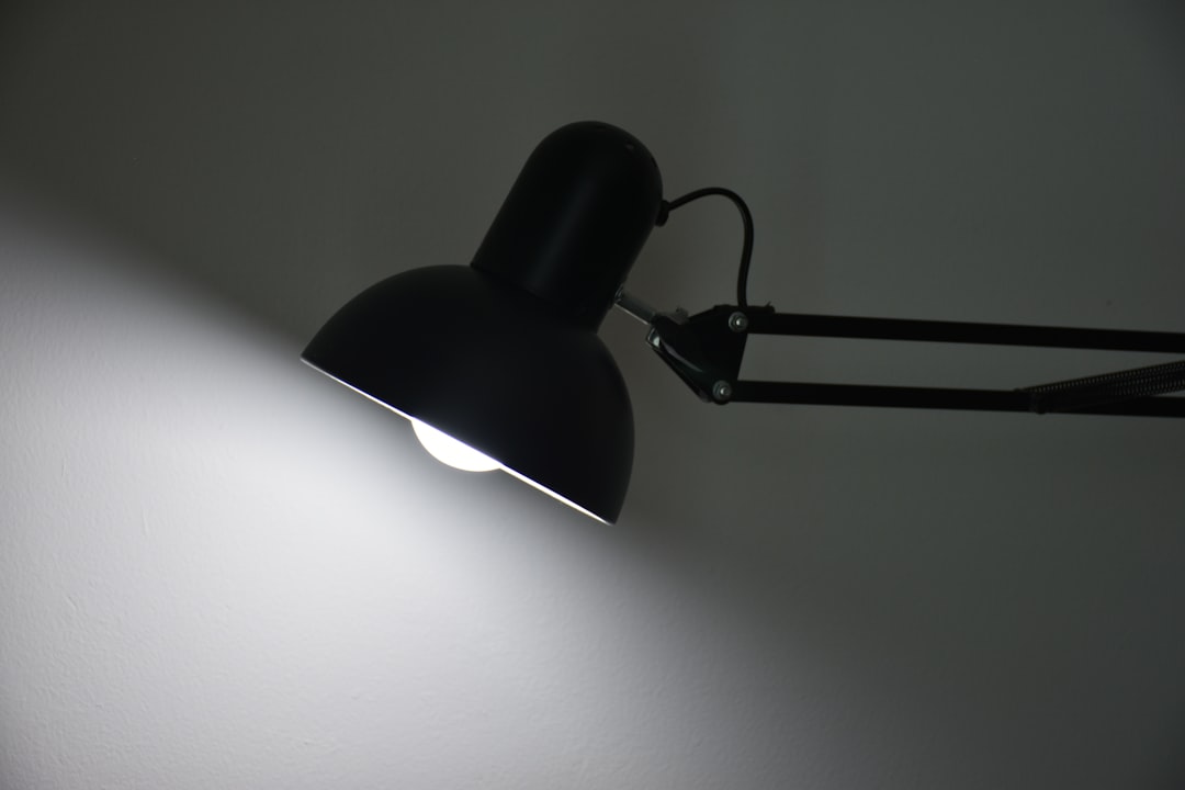 Black desk lamp casting warm task lighting in a home workspace