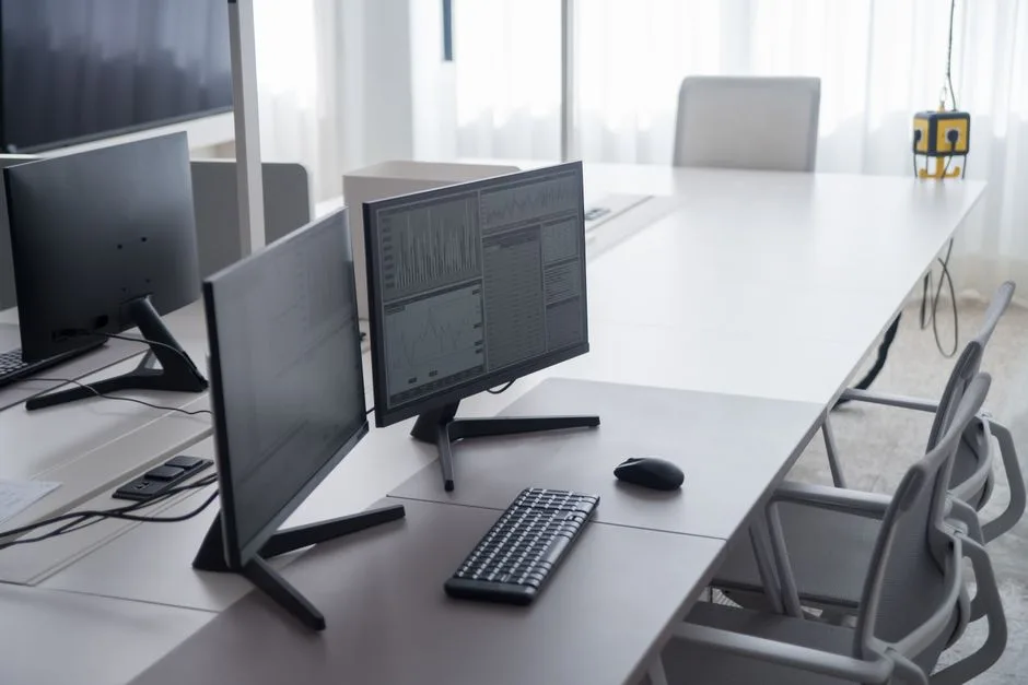 Dual monitor desk setup with keyboard and mouse in a modern office showing space-efficient layout configuration