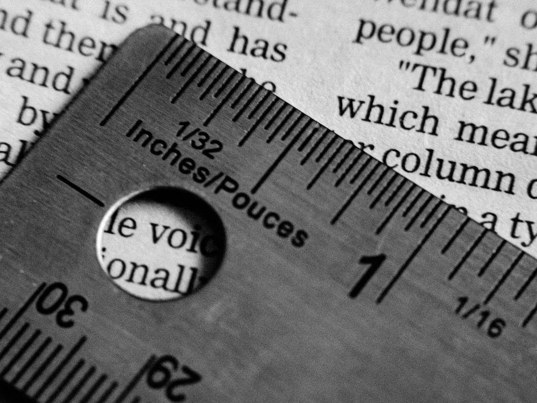 Metal ruler showing 1/32 inch markings placed on open book pages illustrating precise measurement for table sizing decis