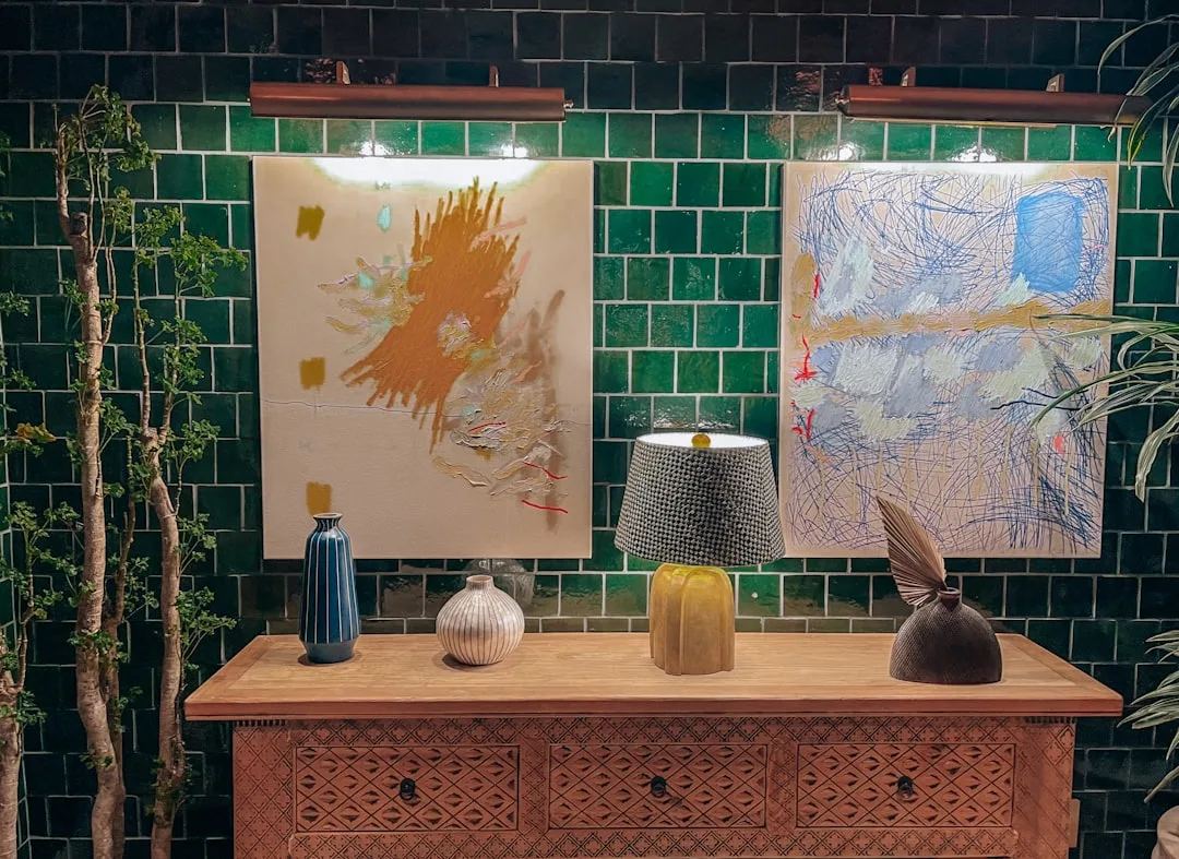 Entry table with fall color palette featuring warm amber, blue, and gold tones with ceramic vases and abstract art on gr