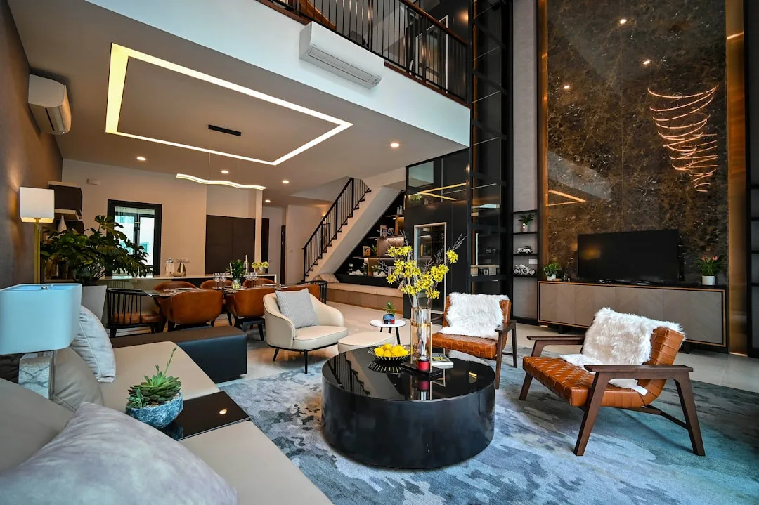 Luxury open-plan living room with defined zones, marble feature wall, black round coffee table, and layered ceiling ligh