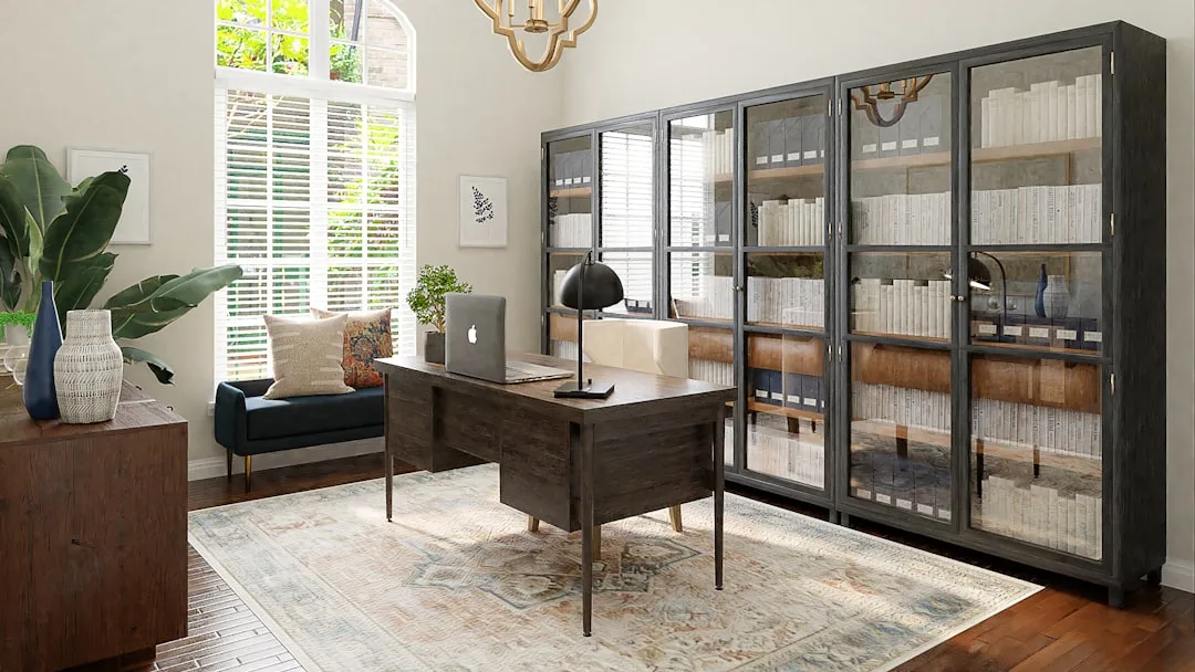 Home office with glass-door cabinet bookcase filled with organized books beside a dark wood executive desk