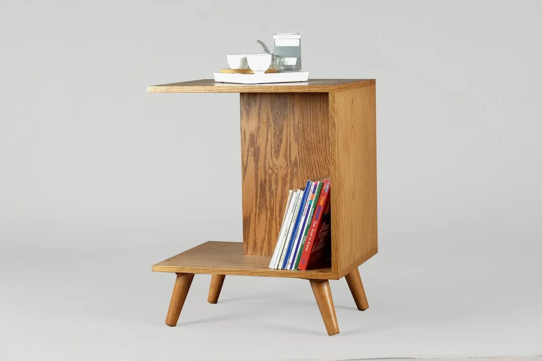 Mid-century modern wooden side table with open shelf storage and tapered legs, styled with books and tea set