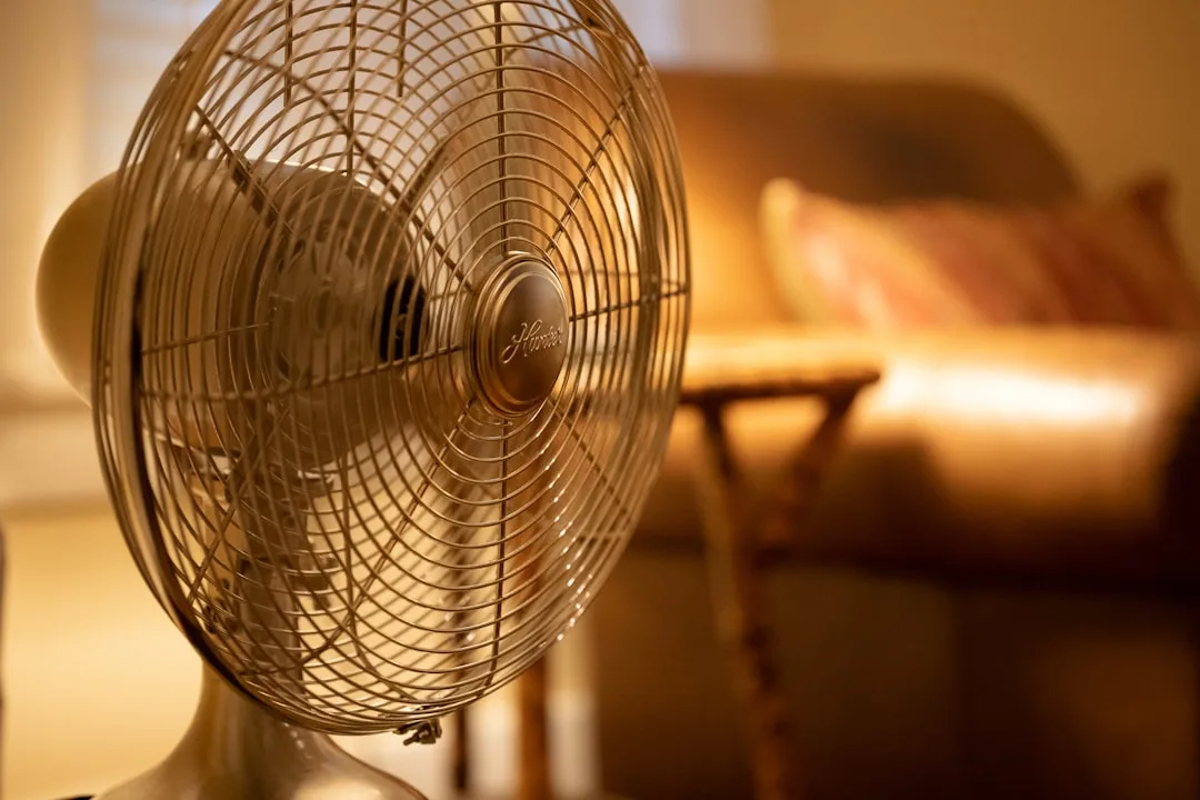 Vintage Hunter brand desk fan with bronze metal grille in warm home living room for ventilation and air circulation
