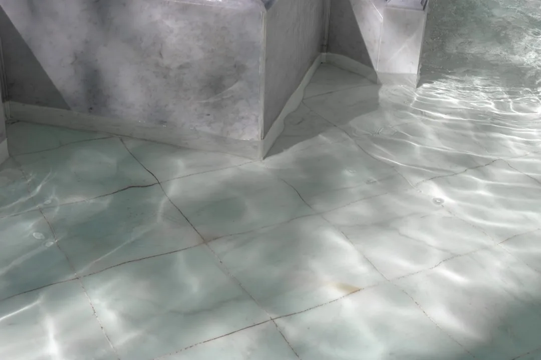 Shallow water rippling over large-format marble ti