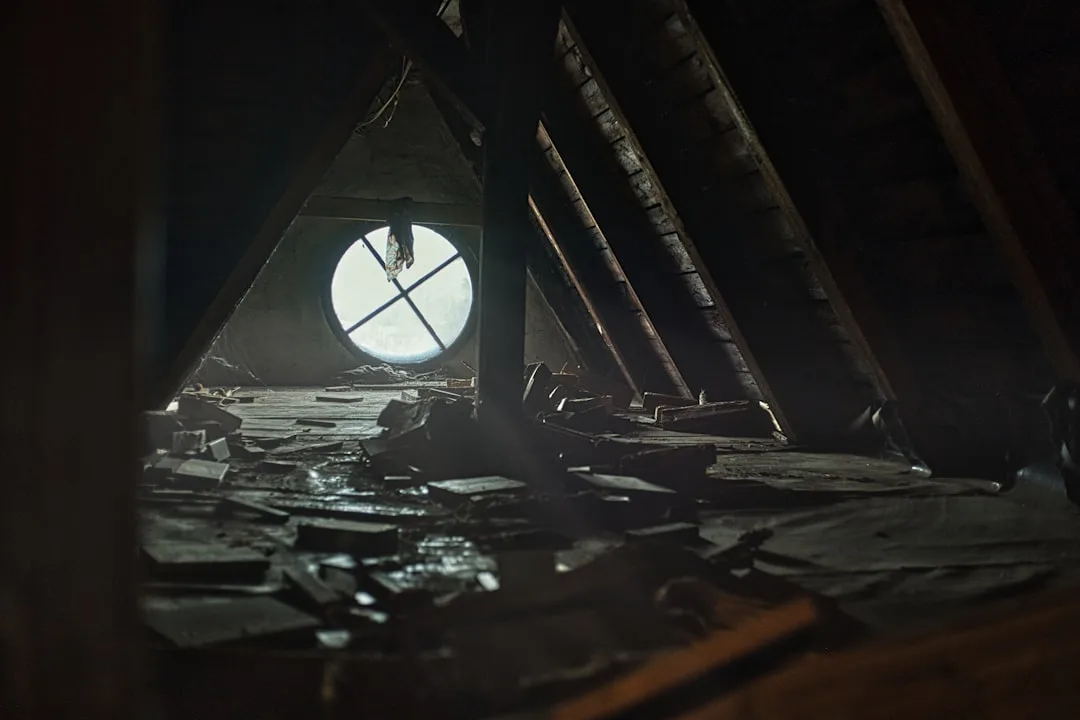 Dark abandoned attic interior with low sloped raft