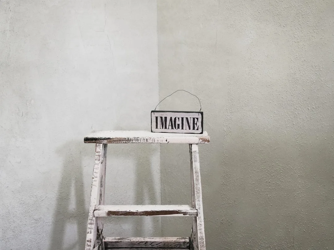 Rustic whitewashed wooden ladder with peeling paint beside a limewash-textured wall