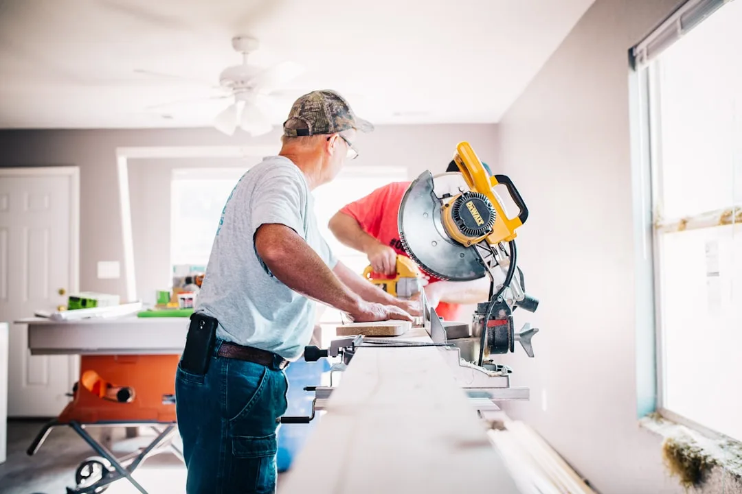 Contractor using DeWalt miter saw during home renovation remodeling project indoors