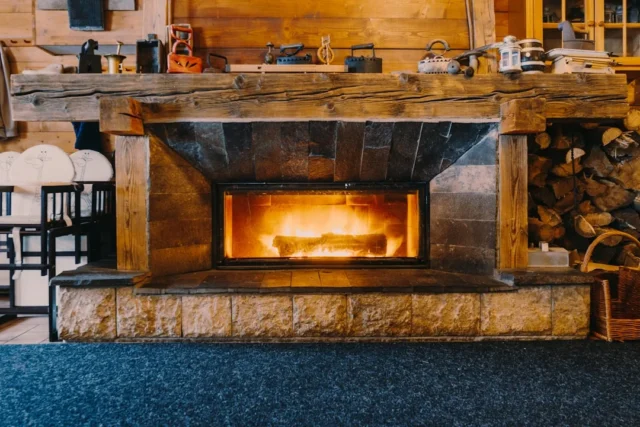 Rustic stone fireplace with wooden mantel surround