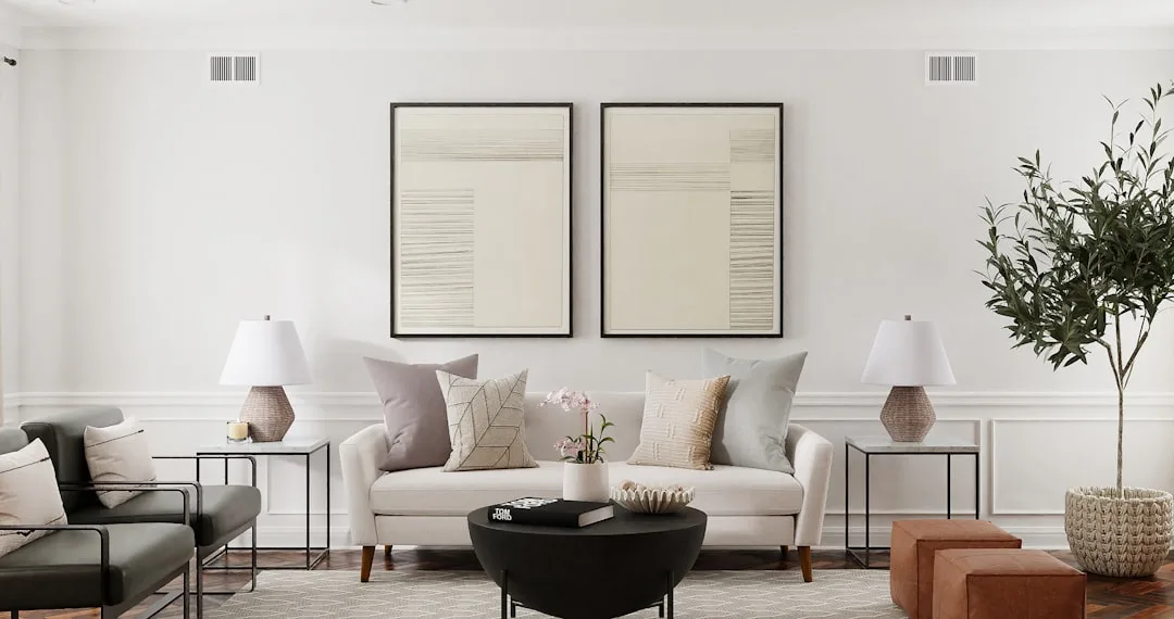 Matching white table lamps flanking a cream sofa with decorative pillows in a modern minimalist living room