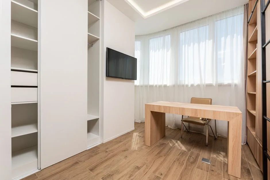 Modern room with open white closet system beside a