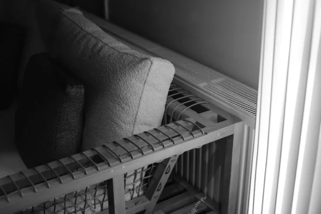 Built-in wooden shelf seating with cushions next t