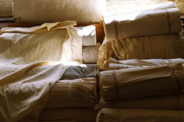 Disorganized stacks of folded linens and fabric ro