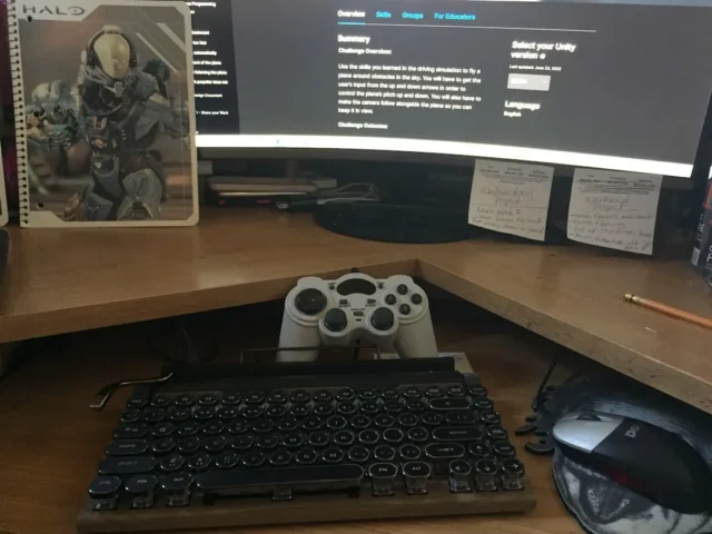 Cluttered corner desk setup with retro keyboard, g