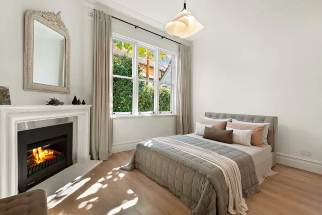Elegant small guest bedroom with white fireplace,