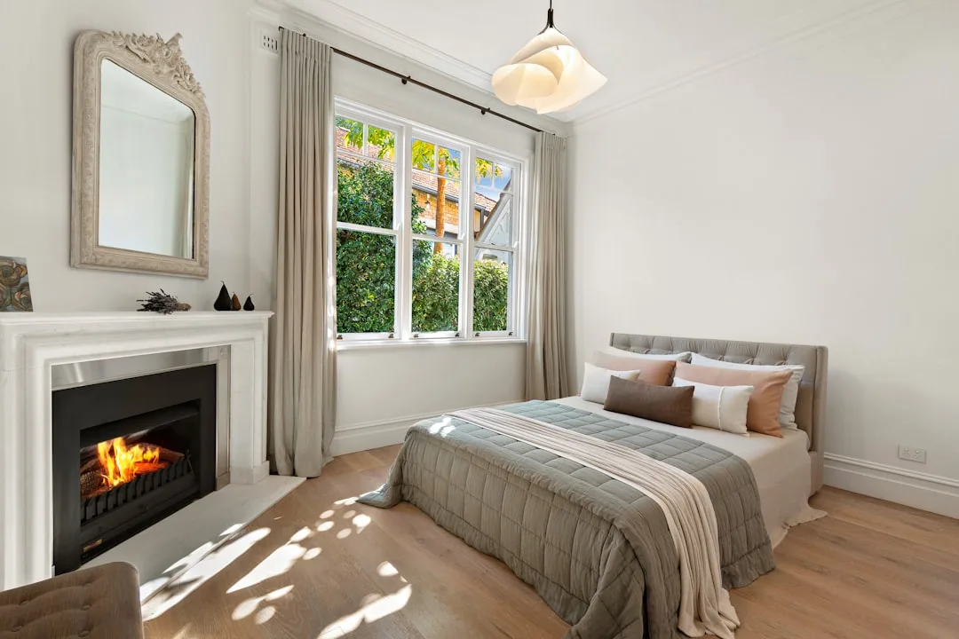 Elegant small guest bedroom with white fireplace,