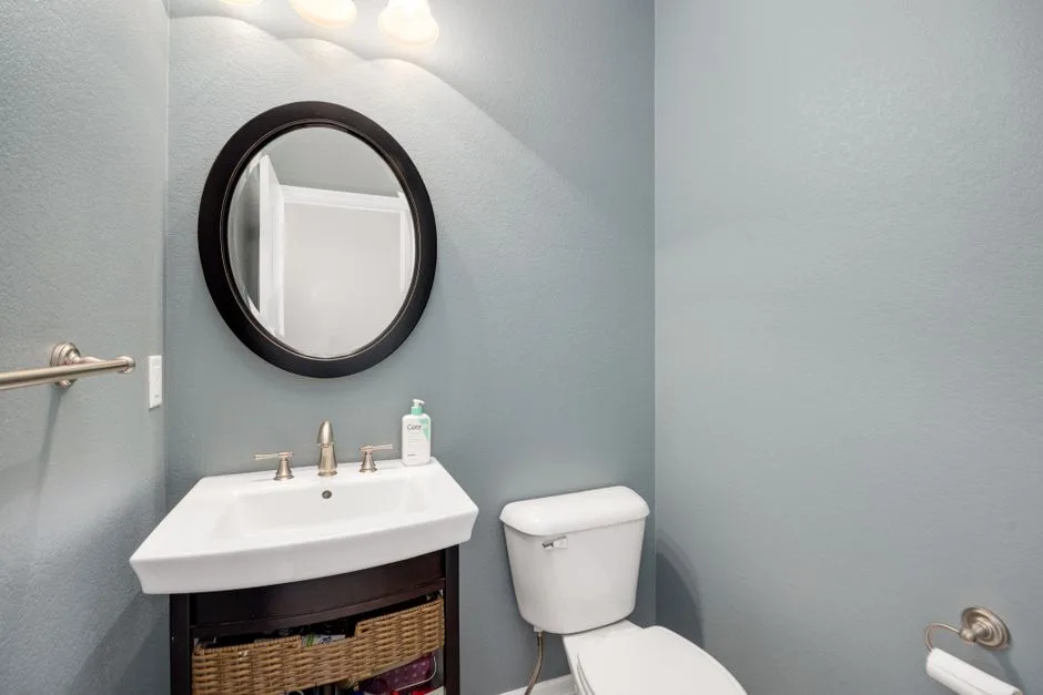 Small half bath with white pedestal sink, round bl