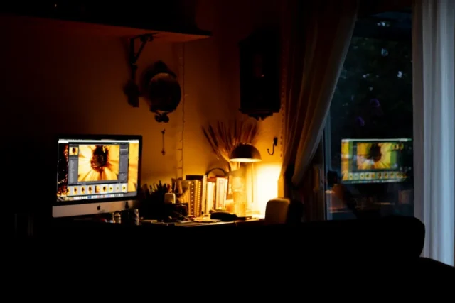 Dark home office with iMac displaying photo editin