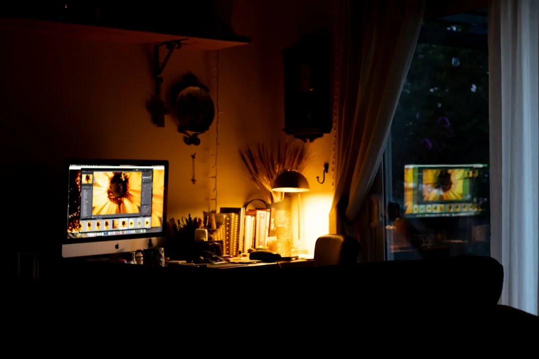 Dark home office with iMac displaying photo editin