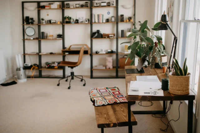 Home office with open metal shelving units filled