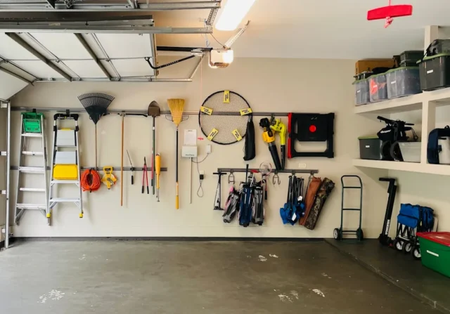 Organized garage wall with tools, golf bags, ladde