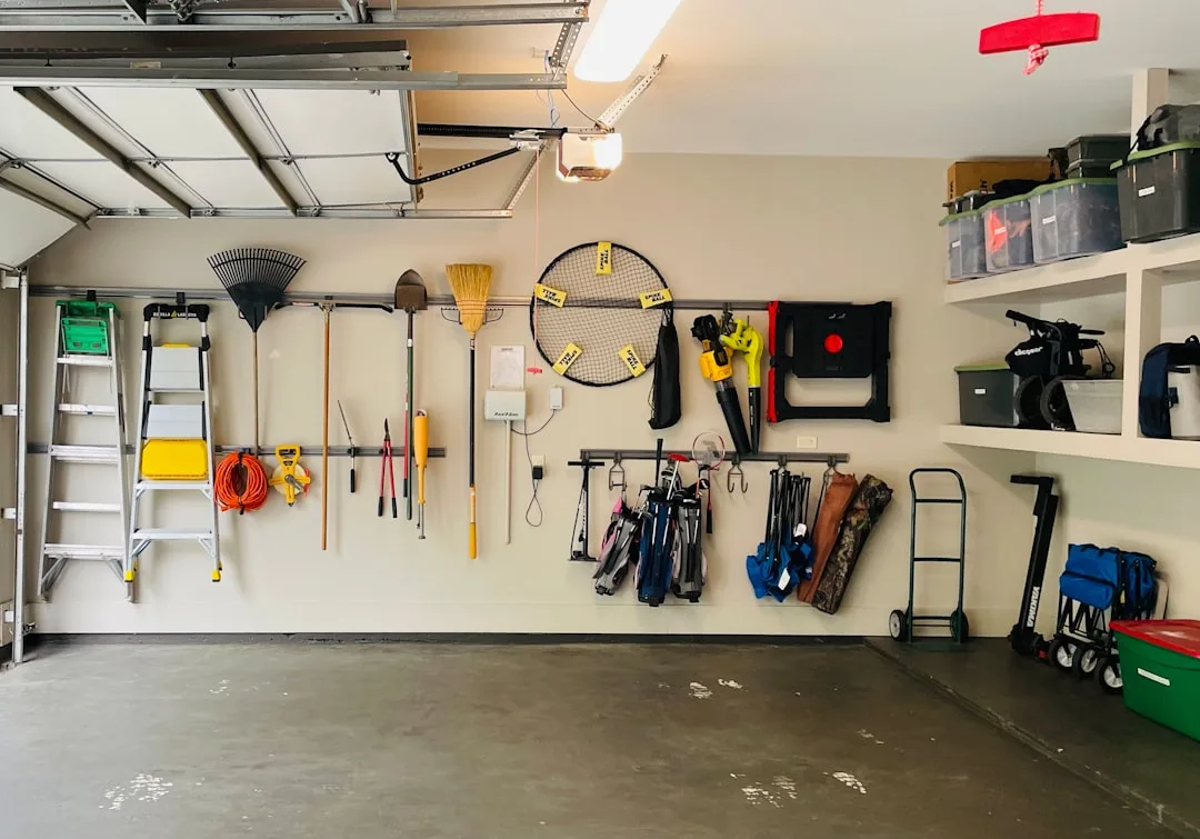 Organized garage wall with tools, golf bags, ladde