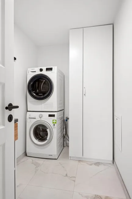 Compact laundry room with stacked washer dryer and