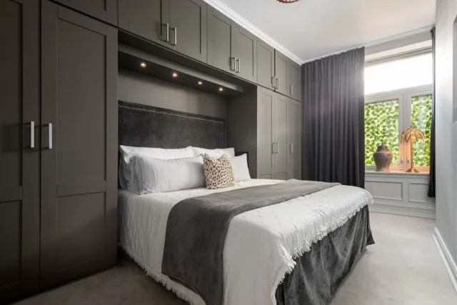 Built-in wall bed with dark grey fitted wardrobes