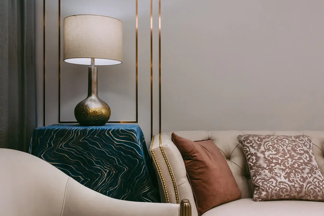 Gold metallic table lamp with linen shade on side