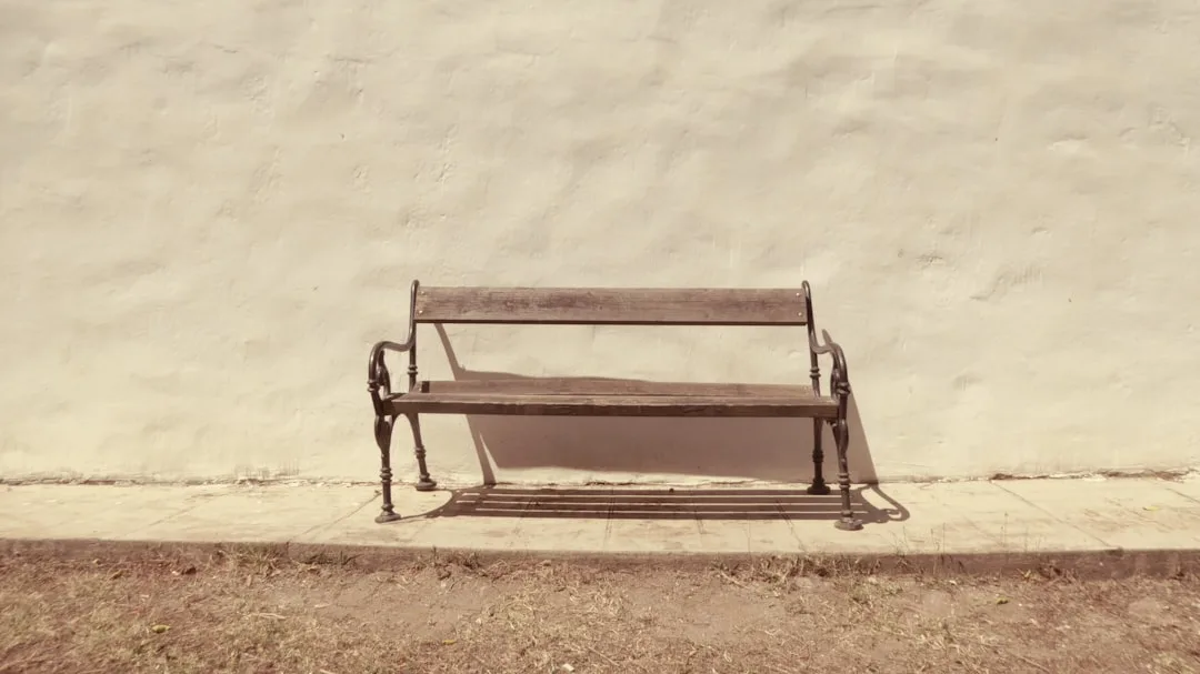 Lone wooden park bench with ornate iron legs again