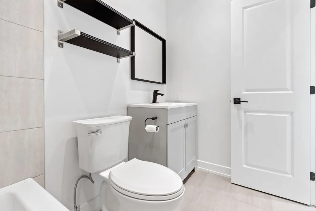 Small modern bathroom with swing door open showing