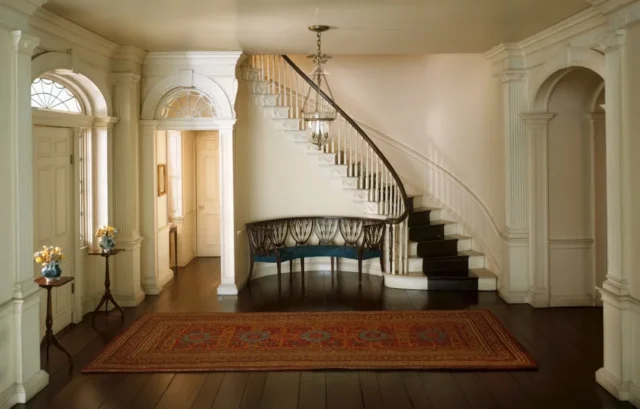 Elegant colonial foyer with curved staircase, orna